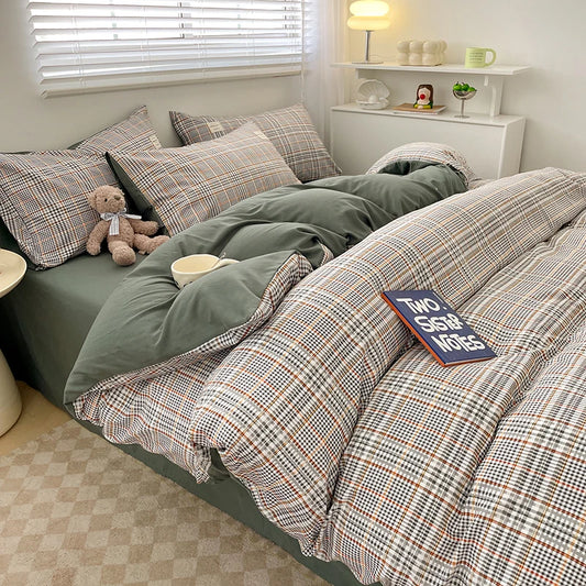 Bed with plaid and solid green bedding, teddy bear, and decorative items in a room.