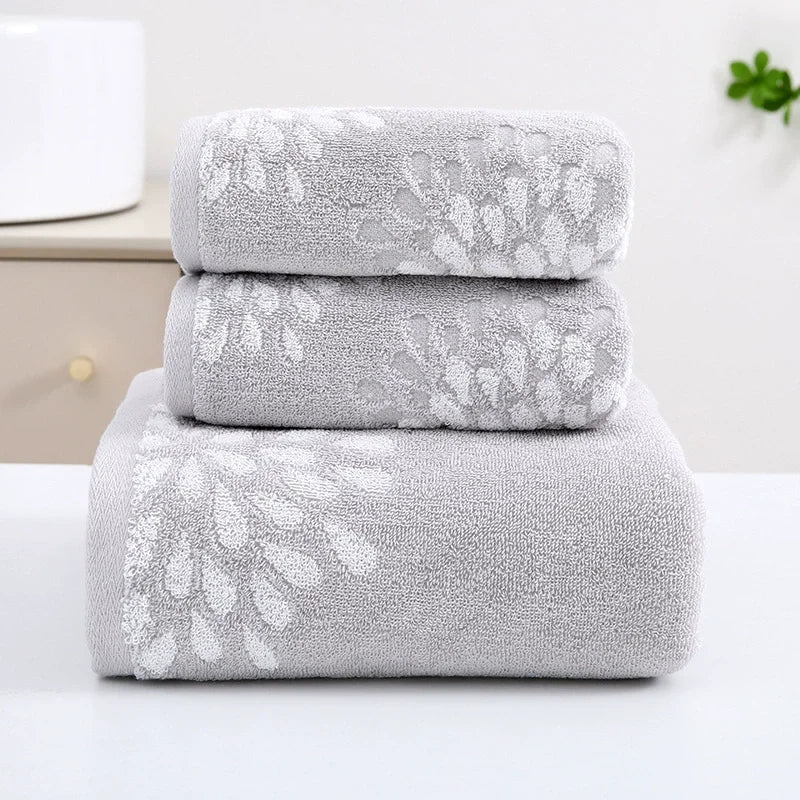 Set of three gray towels with floral patterns on a white background