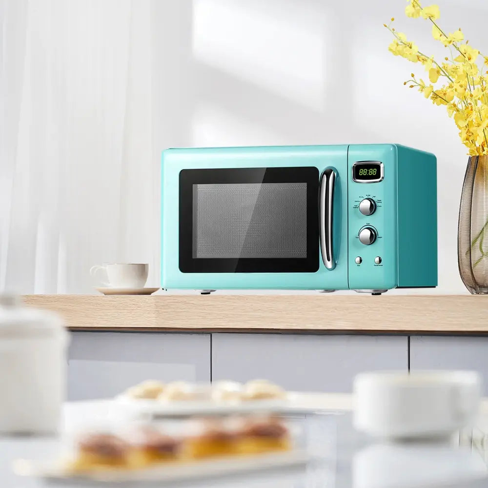 Green retro-style Costway 0.9 cu.ft compact countertop microwave oven with digital controls and modern design.