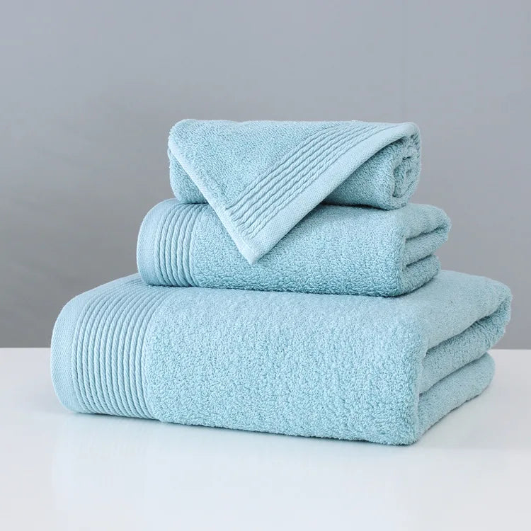 Stack of light blue towels on a white surface with a gray background