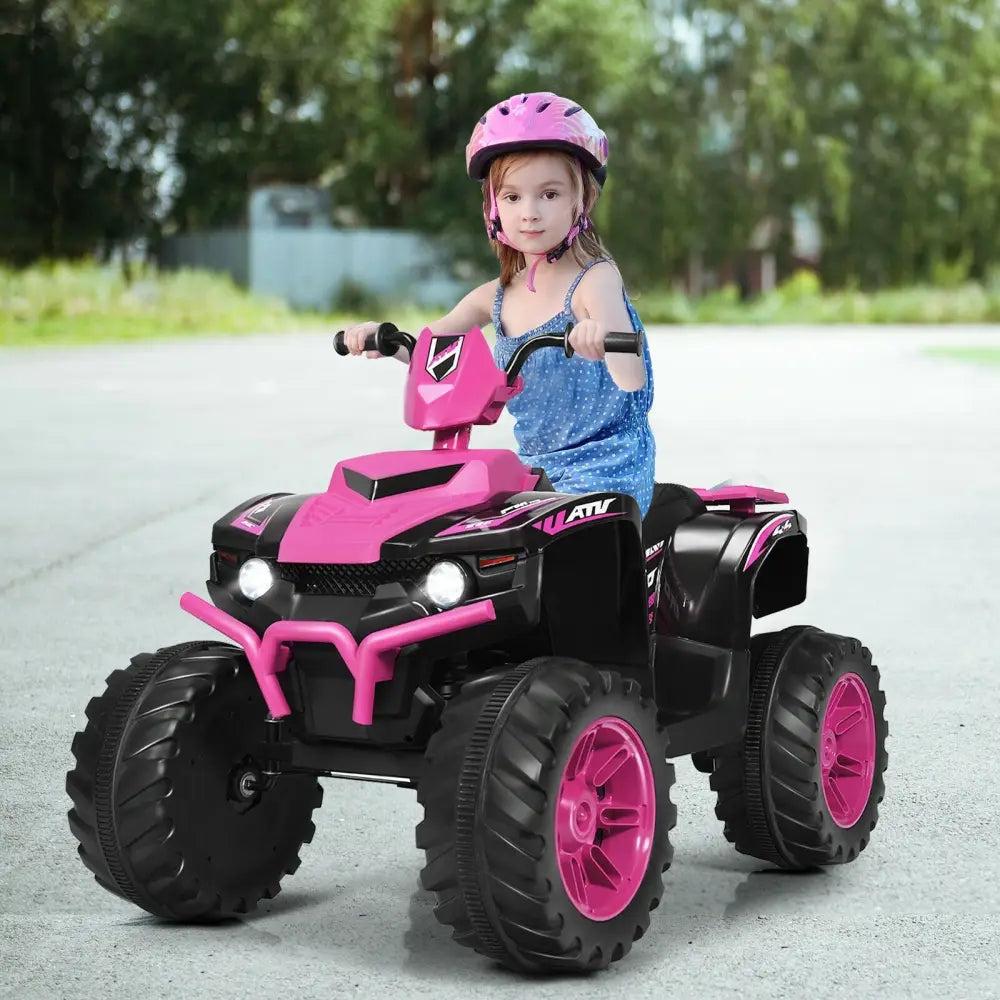 Child riding a pink and black toy ATV on a road with trees in the background
