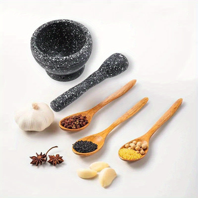 Black mortar and pestle with wooden spoons containing spices on a white background