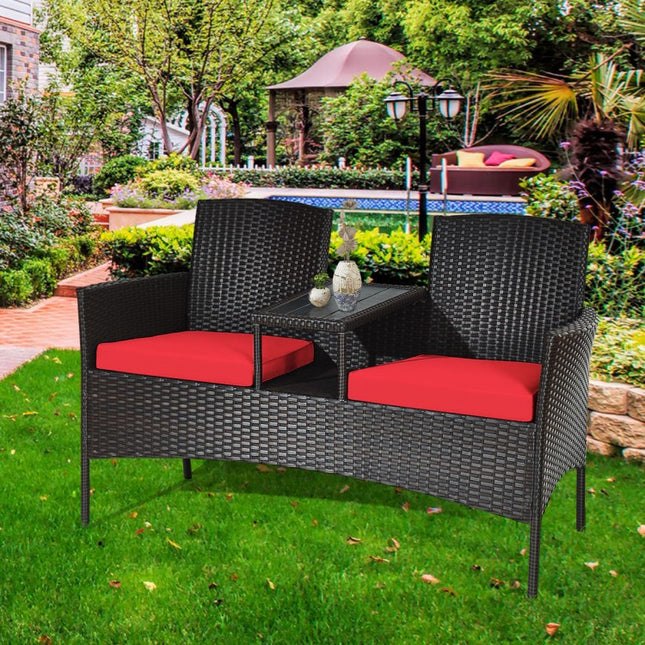 Outdoor patio set with red cushions on a grassy area