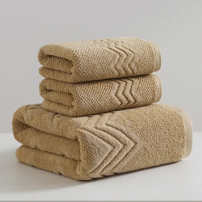 Stack of beige towels with textured pattern on a light gray background