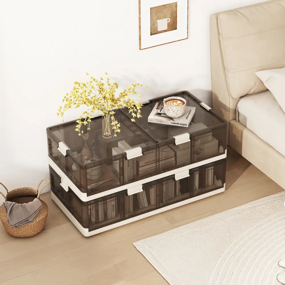 Clear storage box with white accents on a wooden floor next to a bed