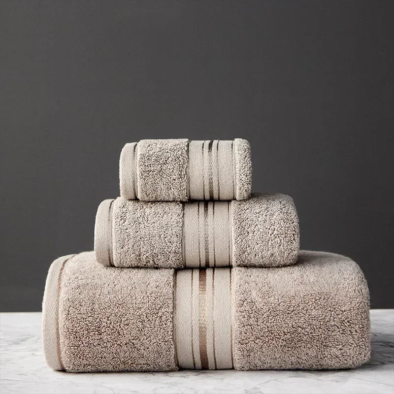 Stack of beige towels with striped patterns on a dark background