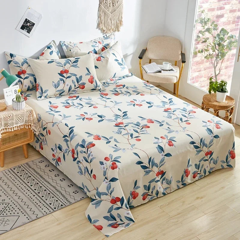 Floral patterned bedspread on a bed in a bright room with a chair and plants.