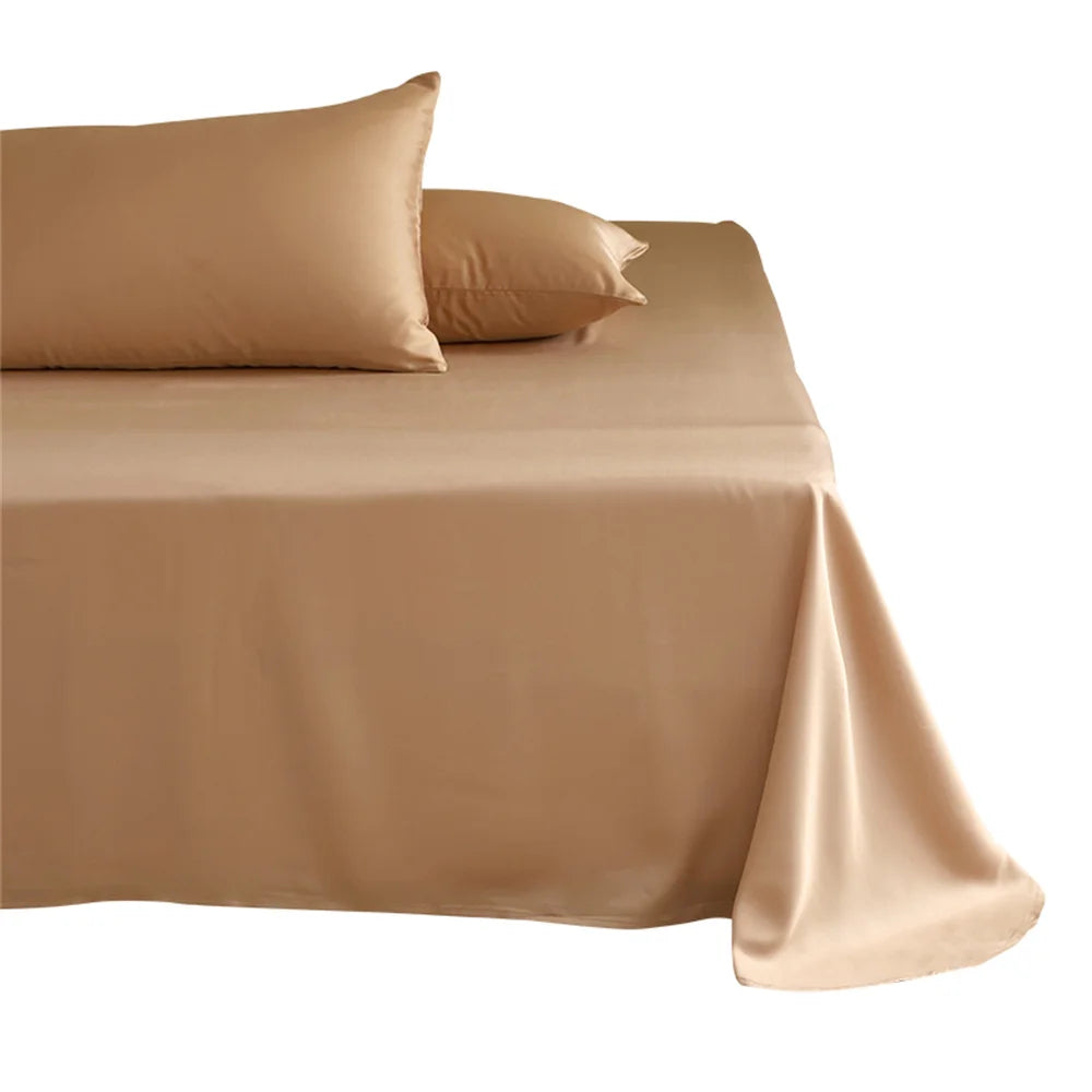 Beige satin sheet set on a bed with two pillows against a white background