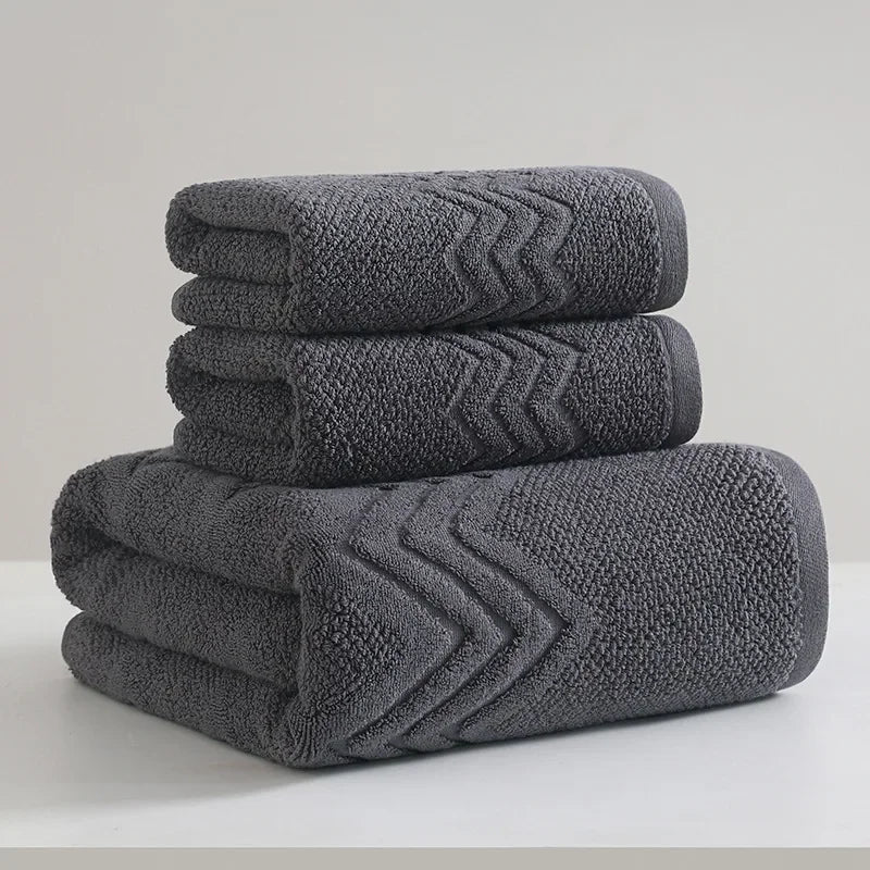 Stack of folded gray towels with a subtle pattern on a light background