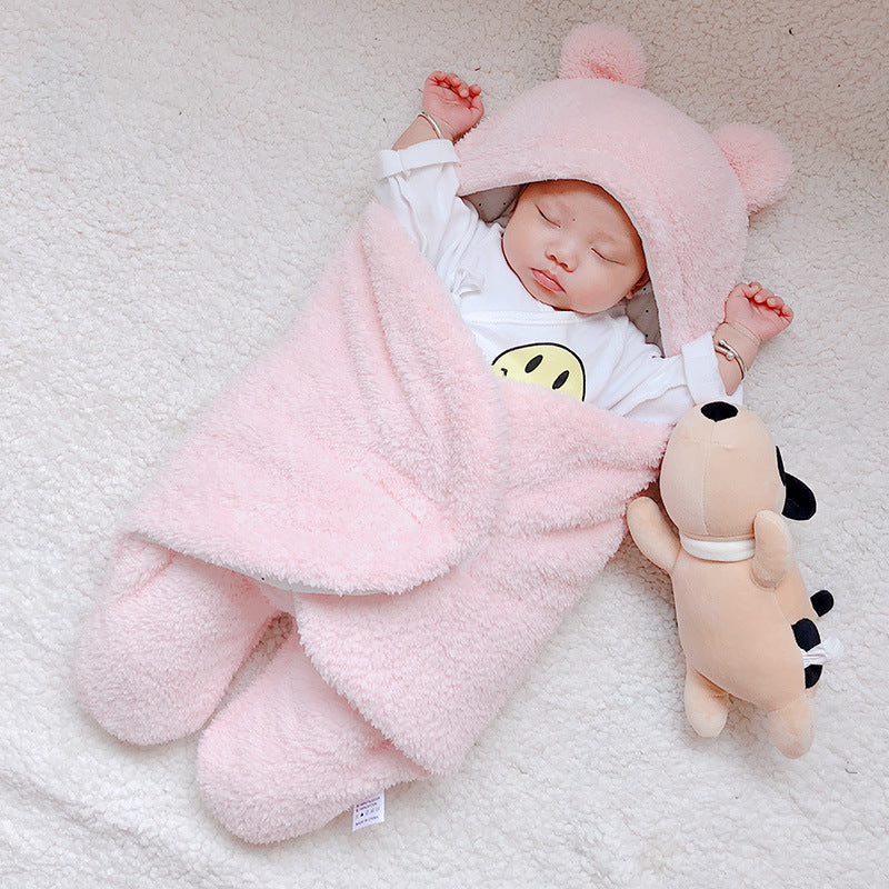 Baby sleeping with pink blanket and plush toy on a white surface