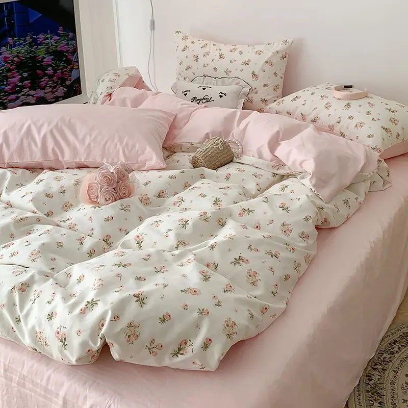 Floral bedding set on a bed with pink pillows and a decorative pillow.
