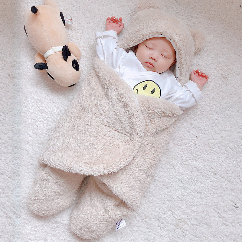 Baby in a fluffy bear costume lying on a soft surface next to a plush toy.