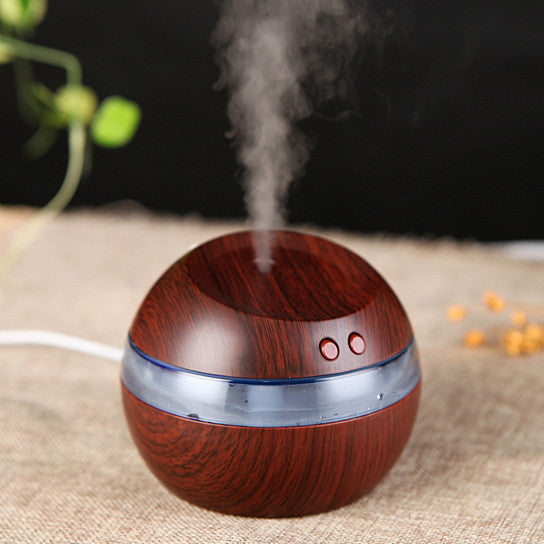 Wooden-textured diffuser emitting steam on a textured surface with a dark background