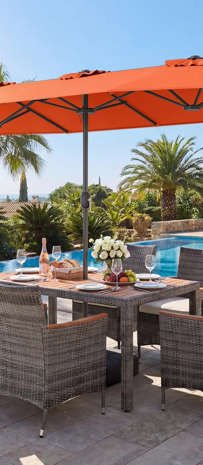 Outdoor dining set with orange umbrella by a poolside