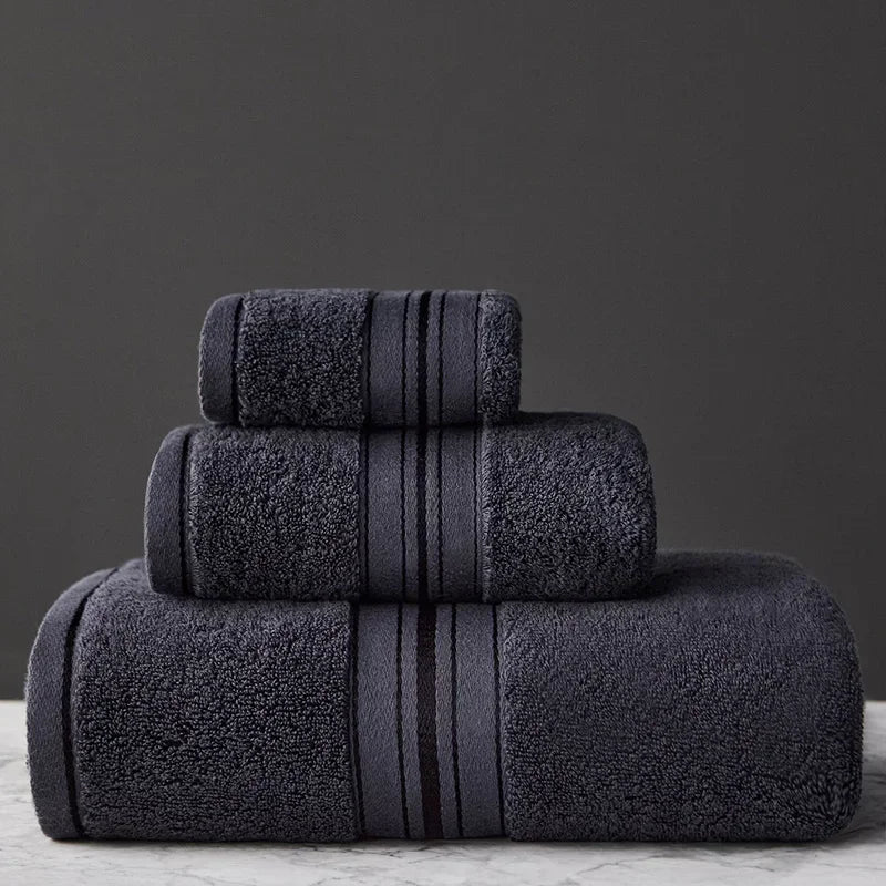 Set of dark gray towels with striped design on a gray background