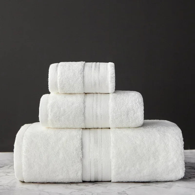 Stack of white towels on a marble surface with a dark background