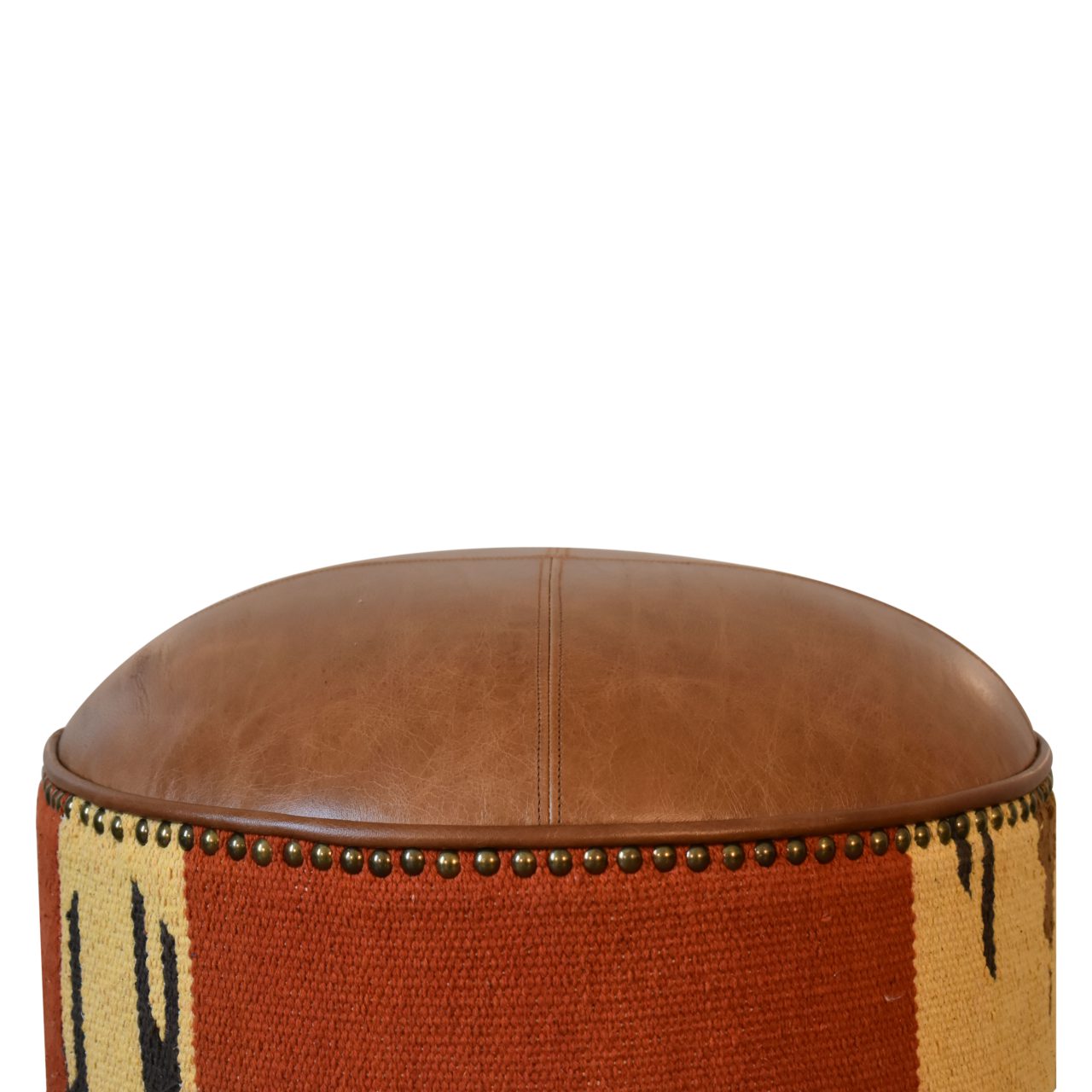 Durrie & Leather Mixed Footstool with Nordic-style legs, buffalo leather, and durrie print. Close view of leather and print.