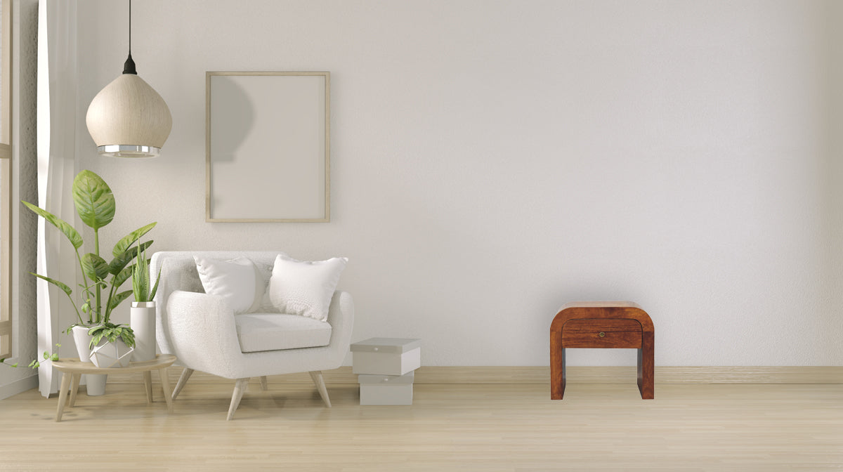 Darcy chestnut nightstand with curved edges and one drawer with brass knob. In a living room view