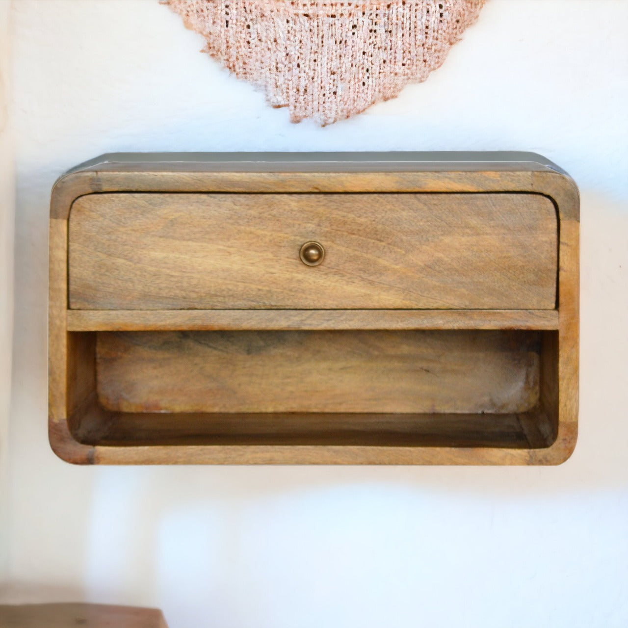 Floating Curve Open Slot Nightstand with one drawer and open shelf, made from solid mango wood. Nightstand mounted on a wall view