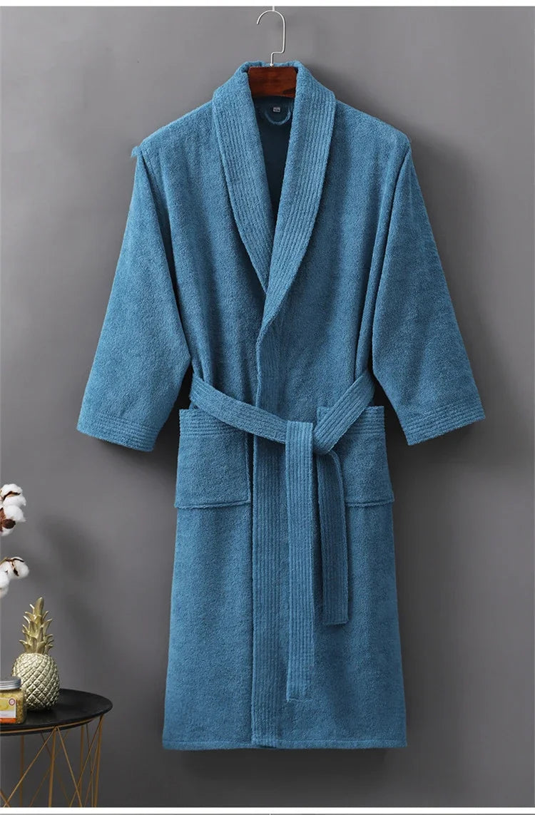 Blue robe hanging on a gray wall with a small table and decorative items in the foreground.