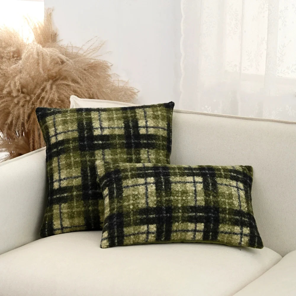 Plaid patterned pillows on a white sofa with a neutral background