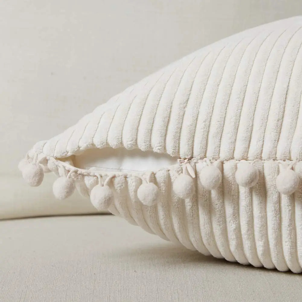 Beige pillow with tassels on a beige background