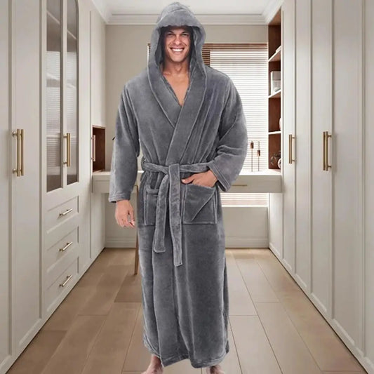 Man wearing a gray hooded robe in a modern bathroom.