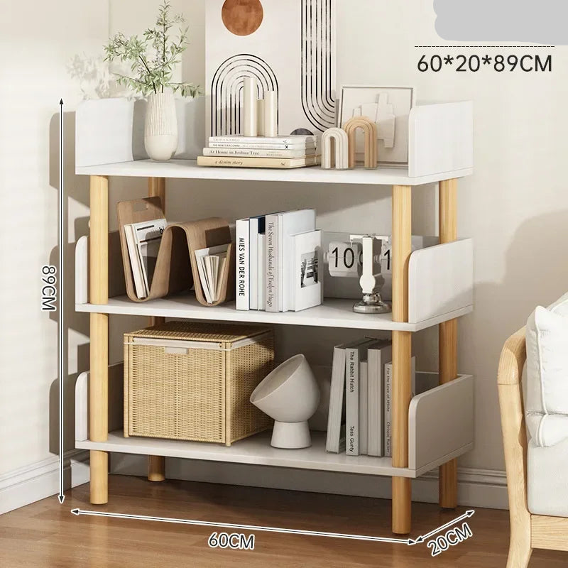 White and wooden shelf with books, decor items, and a basket on a wooden floor.