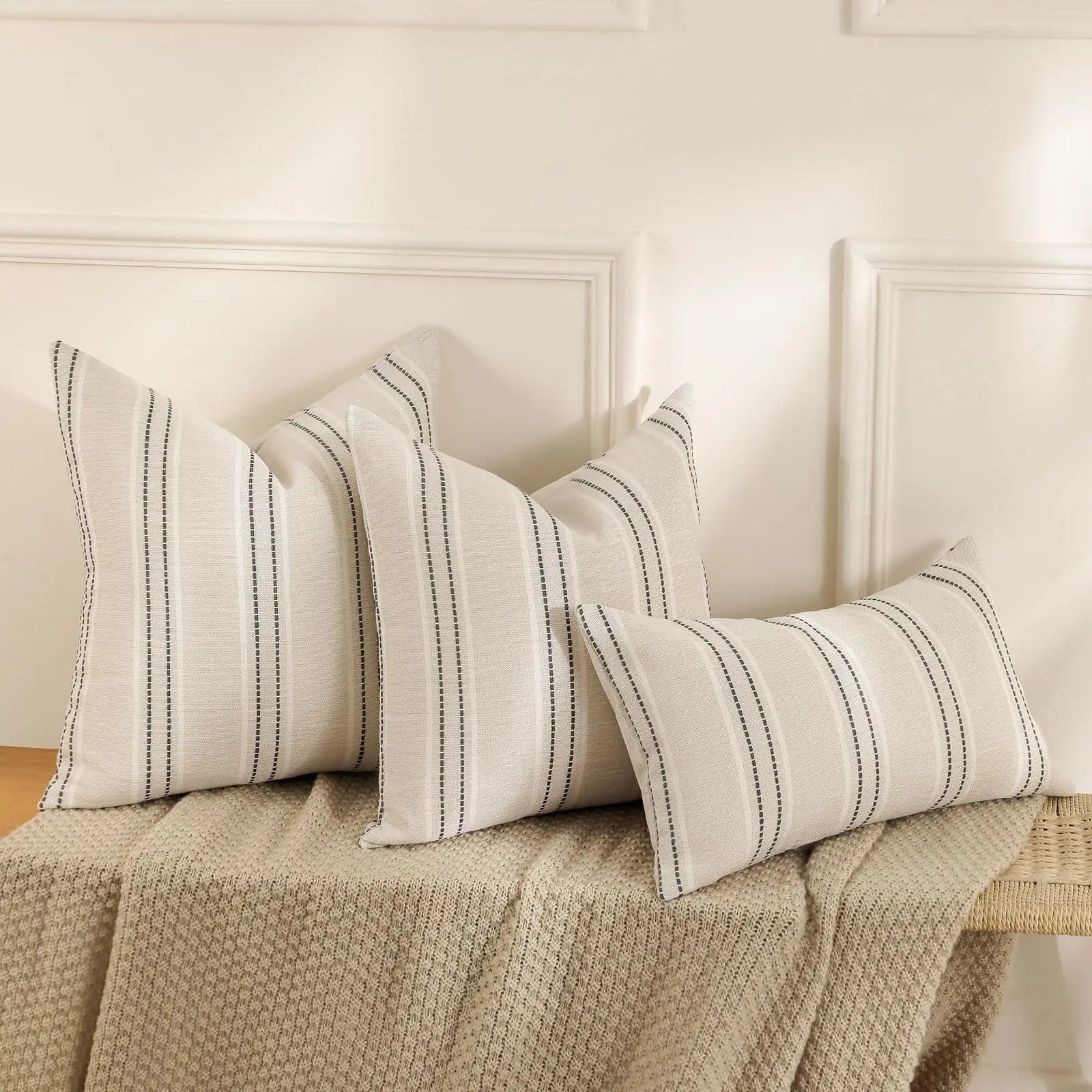 Striped pillows on a bed with a neutral color scheme