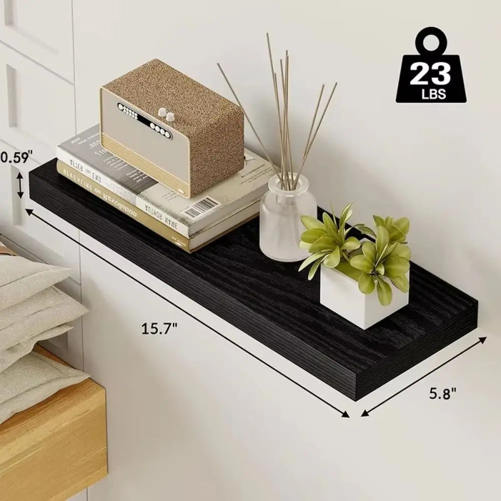 Black wall shelf with books, a box, and a plant, with measurements and weight capacity displayed.
