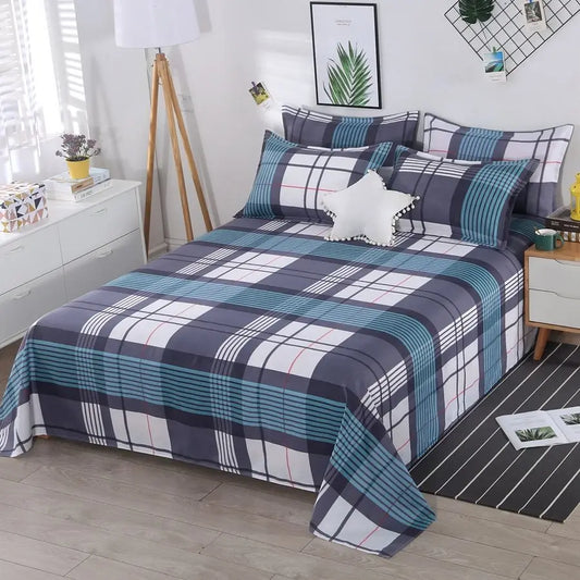 Plaid bedspread on a bed in a bedroom setting with decor elements.