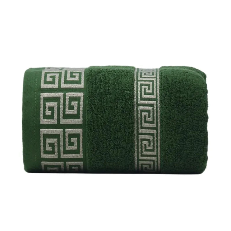 Green towel with decorative white pattern on a white background
