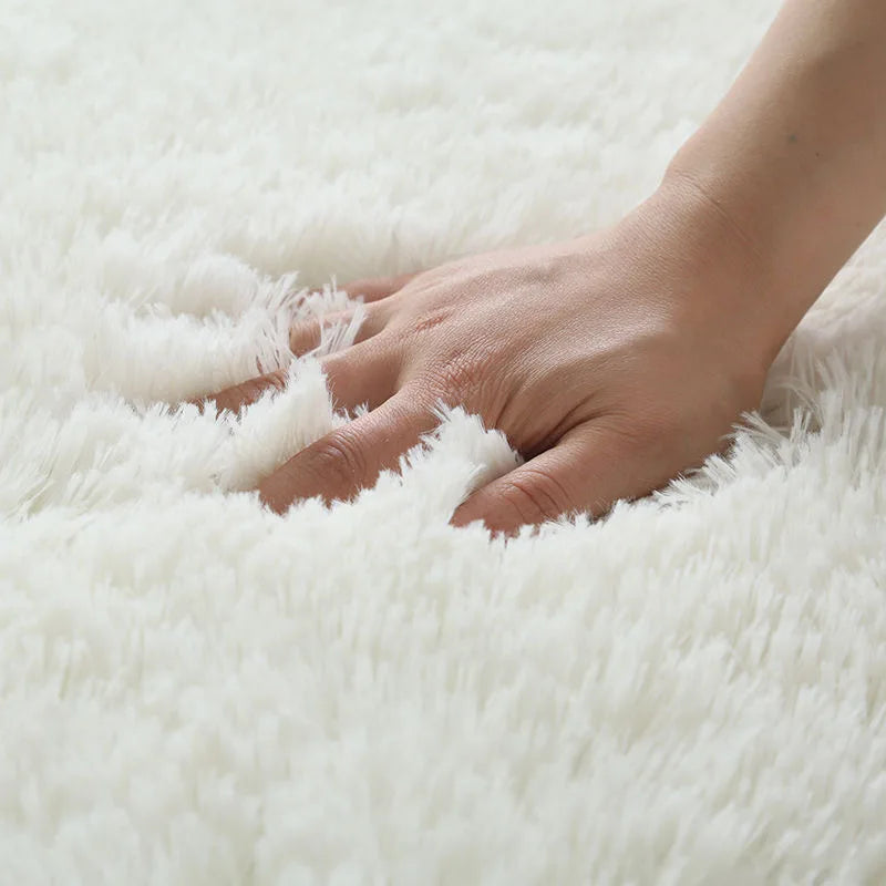 Hand touching a fluffy white rug