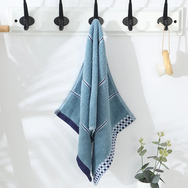 Blue towel hanging on a rack with a white background