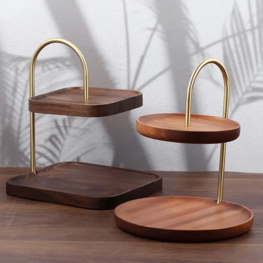 Wooden tiered trays with gold metal stands on a wooden surface.
