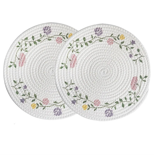Two round woven placemats with floral patterns on a white background