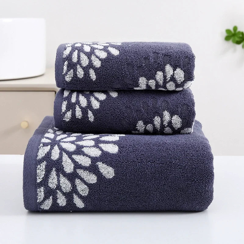 Set of three navy blue towels with white floral patterns on a white background