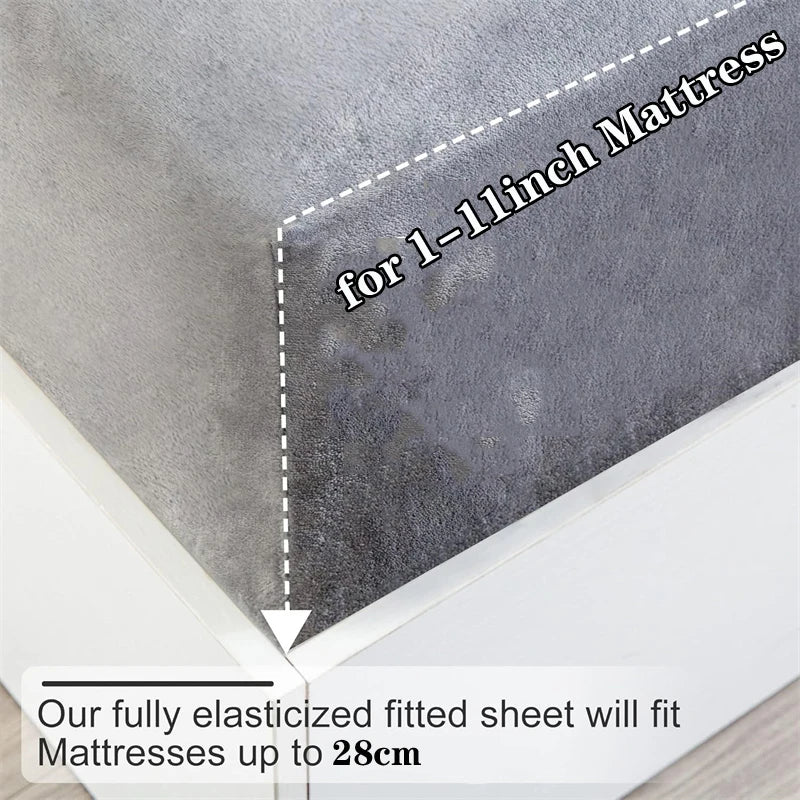 Gray fitted sheet with text on a mattress, showing compatibility for mattresses up to 28cm.