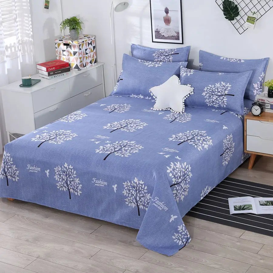 Blue floral patterned bedspread on a bed in a bedroom setting.