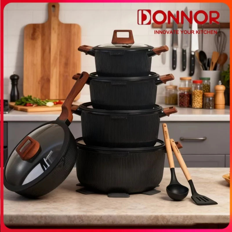 Stack of black cookware with wooden handles on a kitchen counter, featuring the Donnor brand.