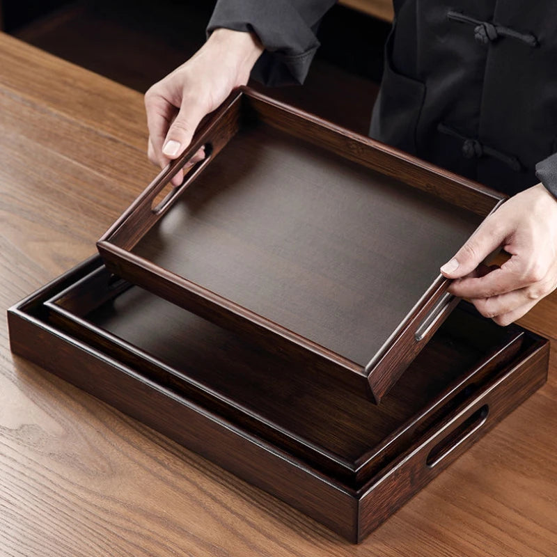 Person holding a wooden tray on a wooden surface