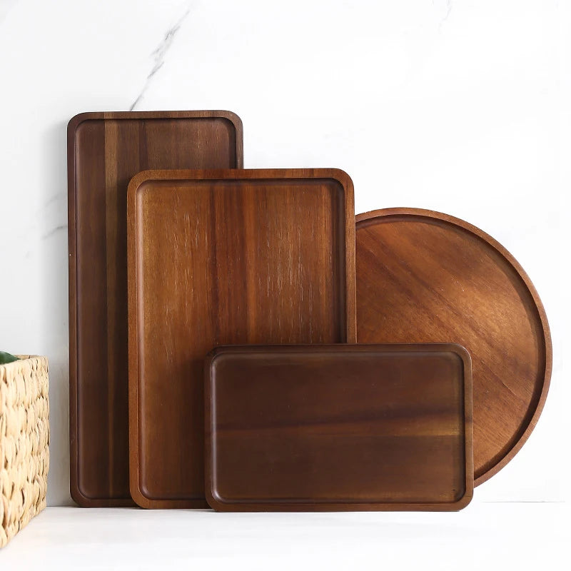 Set of wooden trays in various shapes and sizes on a white surface.
