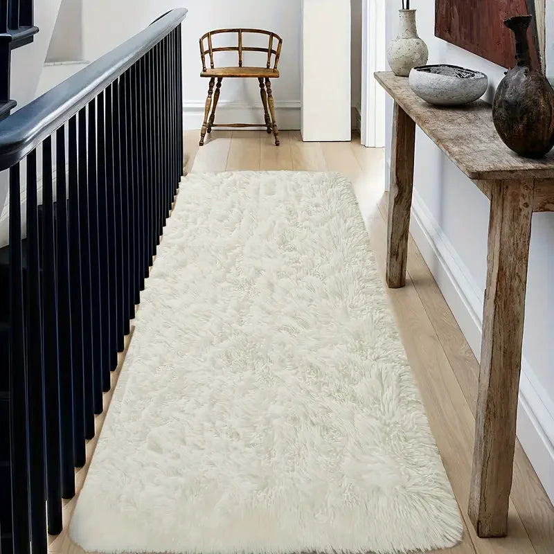 White shaggy rug on a wooden floor with a black staircase and wooden bench in the background.