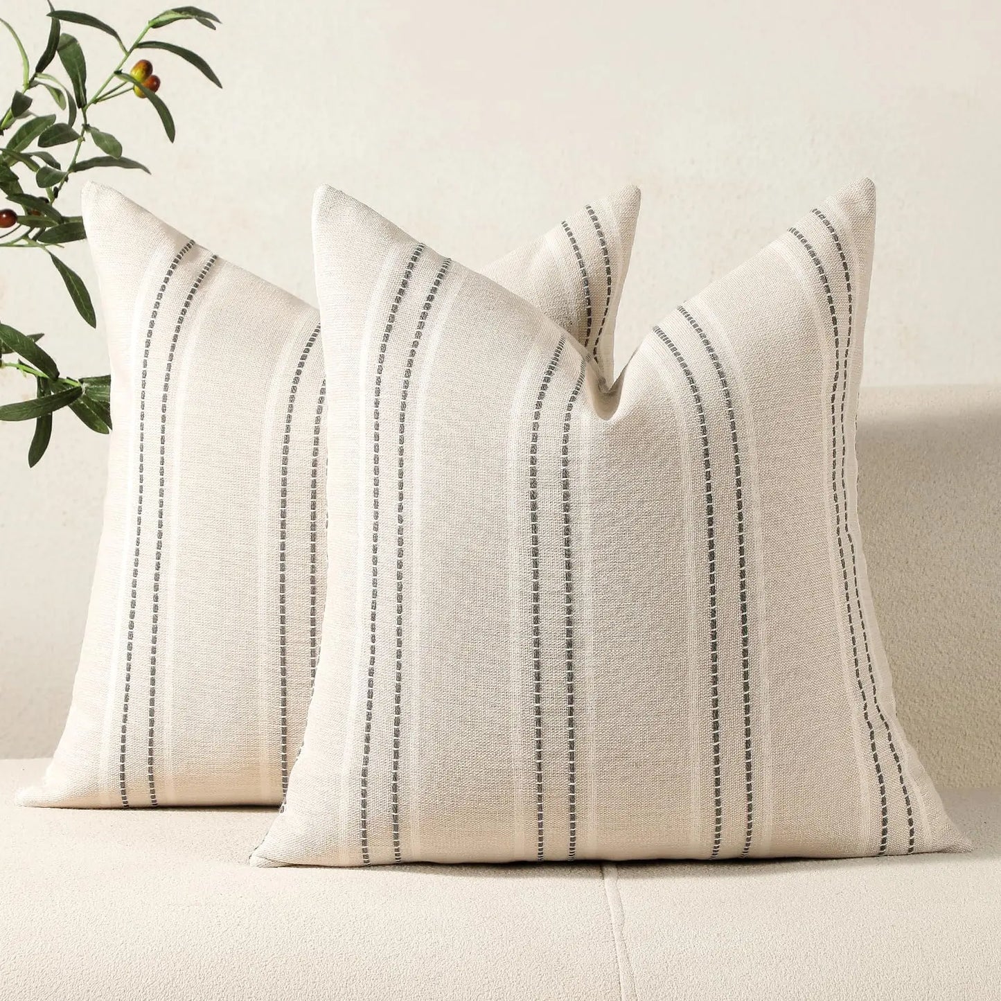 Two striped pillows on a sofa with a neutral background