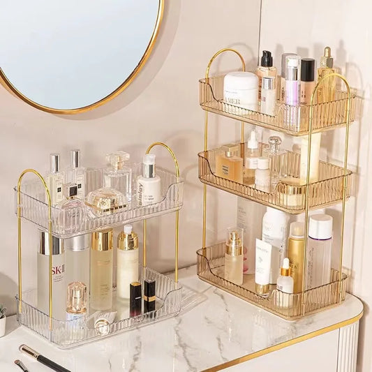 Gold and clear multi-tiered organizer with skincare products on a marble surface.