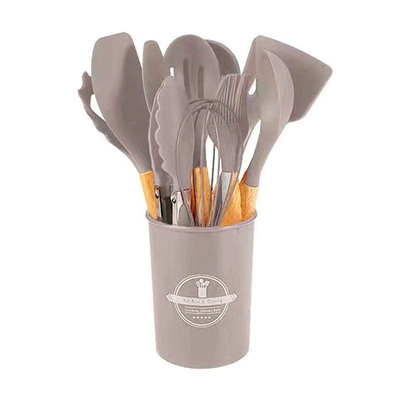 Set of gray kitchen utensils in a cylindrical container on a white background