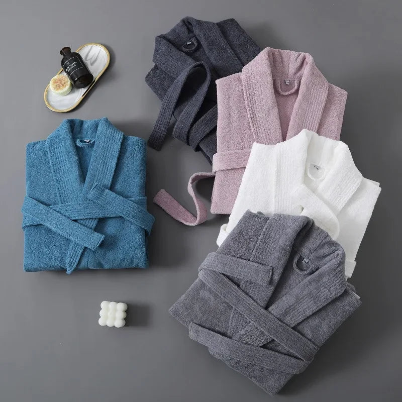 Folded bathrobes in blue, gray, pink, and white on a gray background.