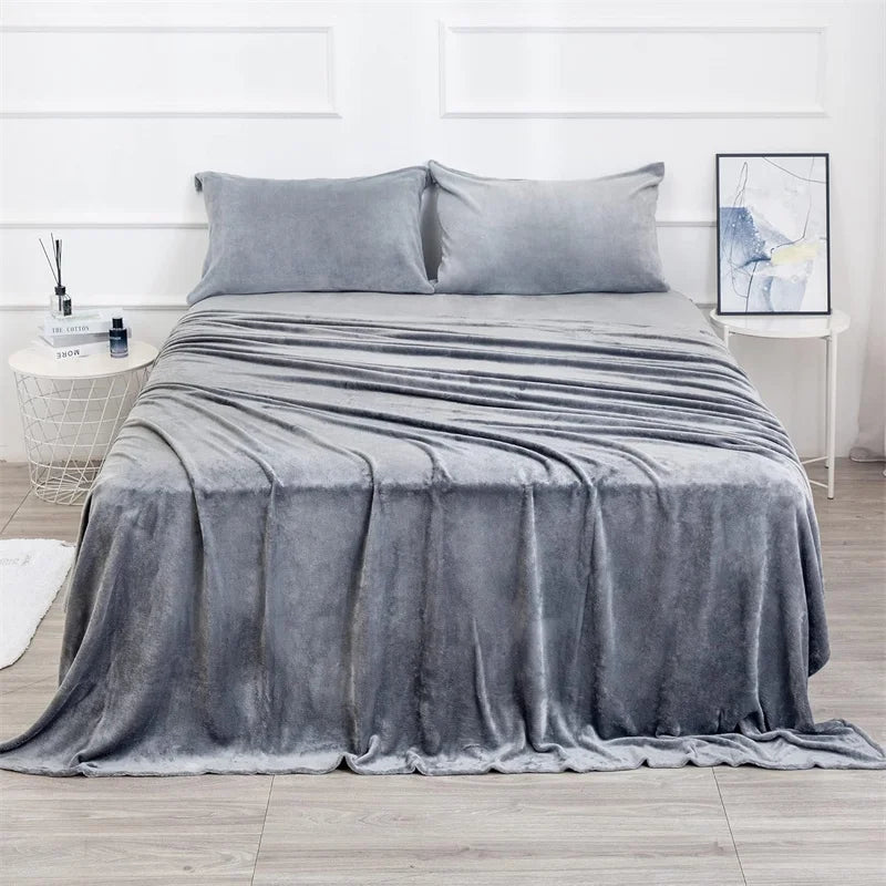 Gray blanket and pillow set on a bed in a bedroom setting