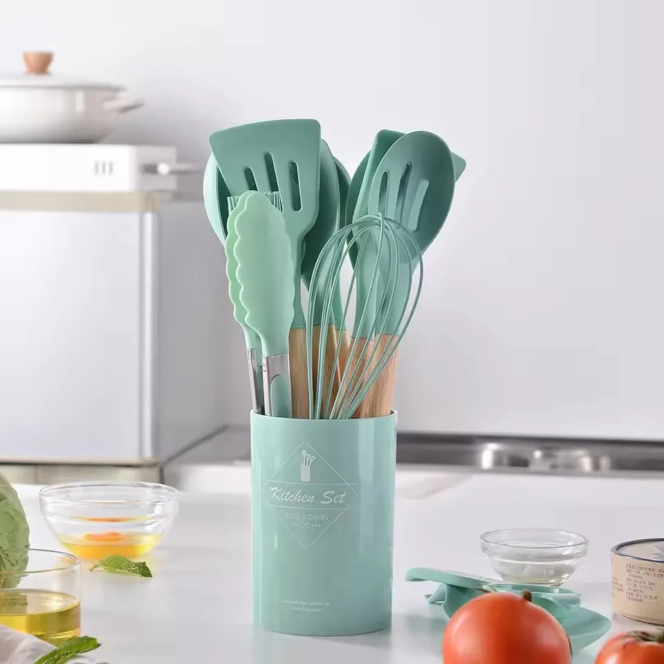 Set of green kitchen utensils in a holder on a kitchen counter.