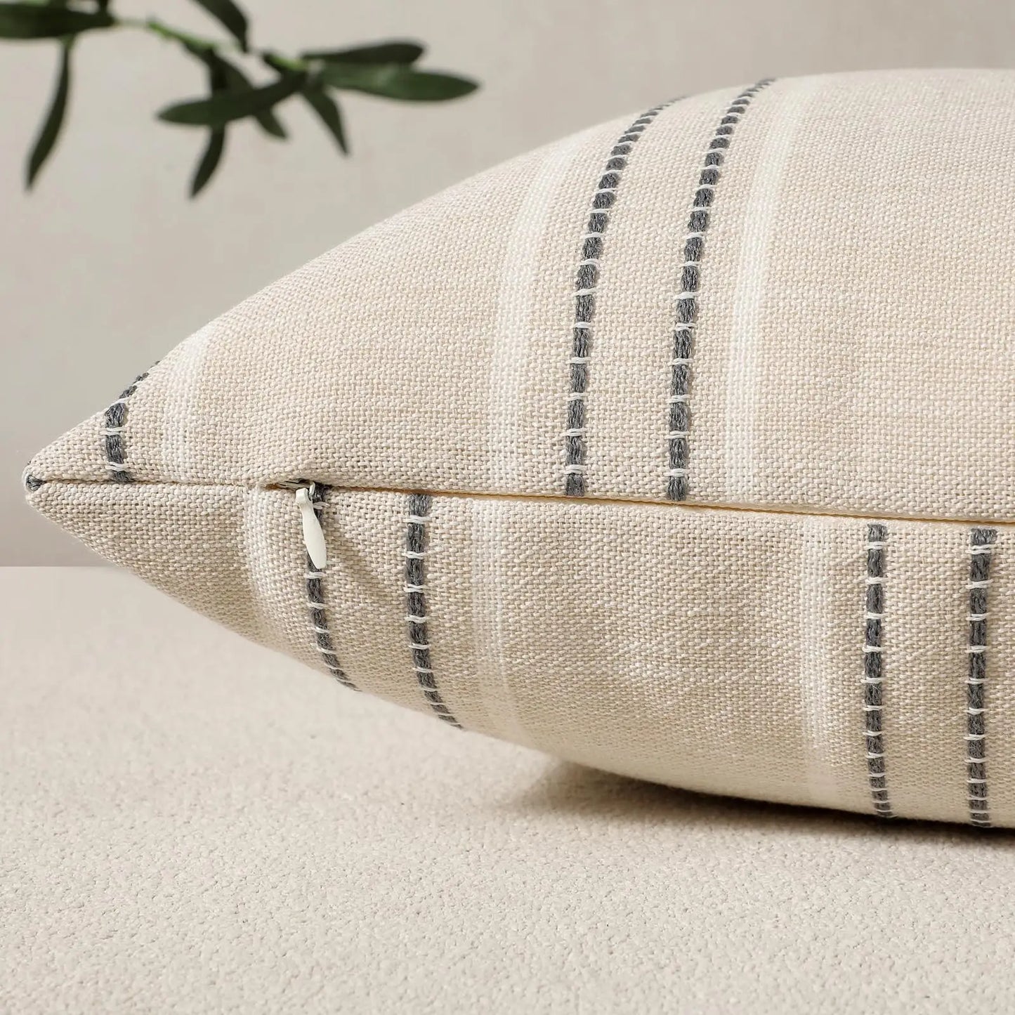 Beige pillow with black stripes on a neutral background